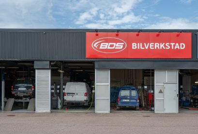 Tre bilar står hos bilverkstad i Hedemora med skylten BDS bilverkstad ovanför.